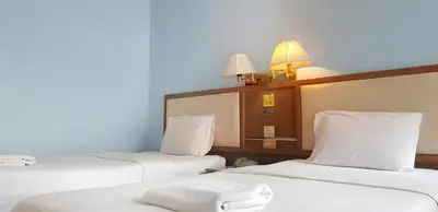 a room with three beds with white sheets and lamps at XX Wish Inn BTS Chidlom - วิช อินน์ บีทีเอส ชิดลม in Pratunam