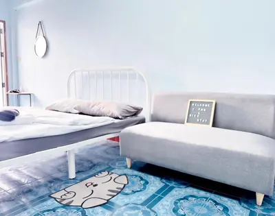 a room with two beds and a bed and a table at Titi-pon Apartment Bang Khen in Bang Khen