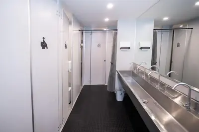 a row of stalls in a bathroom with mirrors at DMK Place in Bangkok