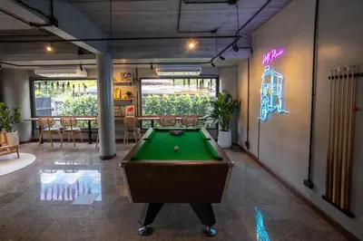 a pool table in a room with a neon sign at DMK Place in Bangkok