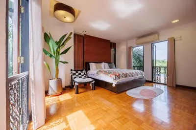 a bedroom with a bed and a potted plant at \u83f2\u65af\u4e4b\u57ce\u66fc\u8c371200\u5e73\u7687\u5bb6\u68ee\u7cfb\u6cf3\u6c60\u6d3e\u5bf9\u522b\u5885 in Bangkok