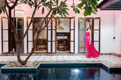 a woman in a pink dress standing next to a swimming pool at \u83f2\u65af\u4e4b\u57ce\u66fc\u8c371200\u5e73\u7687\u5bb6\u68ee\u7cfb\u6cf3\u6c60\u6d3e\u5bf9\u522b\u5885 in Bangkok