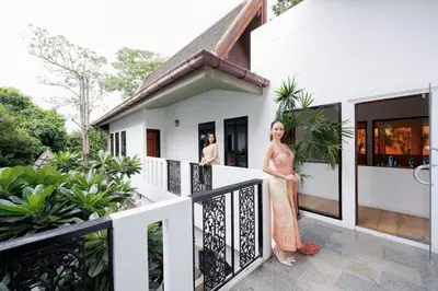 a woman standing on the balcony of a house at \u83f2\u65af\u4e4b\u57ce\u66fc\u8c371200\u5e73\u7687\u5bb6\u68ee\u7cfb\u6cf3\u6c60\u6d3e\u5bf9\u522b\u5885 in Bangkok