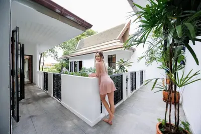 a woman in a pink dress standing on a balcony at \u8fea\u5965\u82b1\u56ed\u66fc\u8c37\u661f\u7a7a\u6cf3\u6c60\u82b1\u56ed\u6d3e\u5bf9\u522b\u5885 in Bangkok