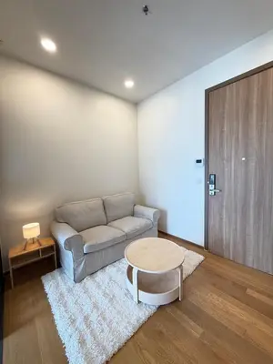 a living room with a couch and a table at Brand New Condo in Bangkok