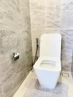 a white toilet in a bathroom with a tile wall at Brand New Condo in Bangkok