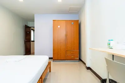 a bedroom with a bed and a wooden cabinet at The Hidden Giant Swing เดอะ ฮิดเด้น เสาชิงช้า in Bangkok