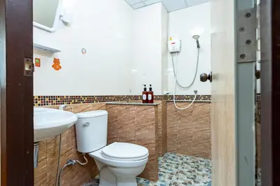 a bathroom with a toilet and a sink and a shower at The Hidden Giant Swing เดอะ ฮิดเด้น เสาชิงช้า in Bangkok