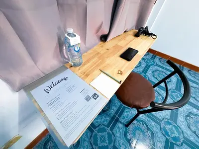 a table with a bottle of water and a chair at ฐิติพร อพาร์ทเมนต์ บางเขน in Tha Akatsayan Don Muang