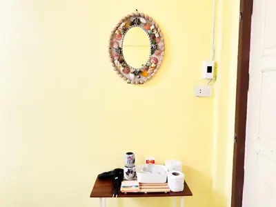 a table with a mirror on a yellow wall at ฐิติพร อพาร์ทเมนต์ บางเขน in Tha Akatsayan Don Muang