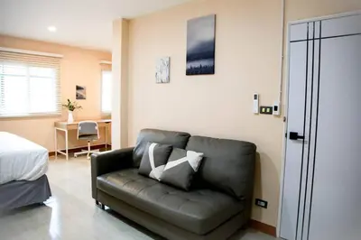 a living room with a couch and a bed at Near BTS Bearing Skytrain- Homey living Townhome - 4 Bedrooms in Bangkok