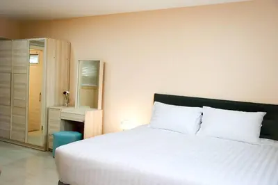 a bedroom with a large white bed and a desk at Near BTS Bearing Skytrain- Homey living Townhome - 4 Bedrooms in Bangkok