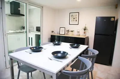 a kitchen with a table and chairs with bowls on it at Near BTS Bearing Skytrain- Homey living Townhome - 4 Bedrooms in Bangkok