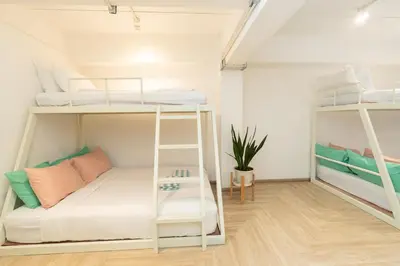 a room with bunk beds and a couch at The Green Khaosan Bangkok in Bangkok
