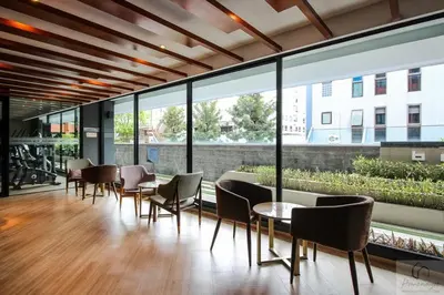 a room with chairs and tables and large windows at brown condo Phahon67 in Ban Chuat Plai Mai