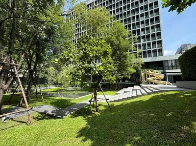 a playground in a park with a tall building at King Bed Studio in Bangkok