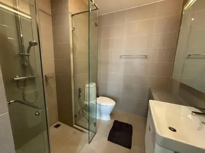 a bathroom with a toilet and a glass shower at King Bed Studio in Bangkok