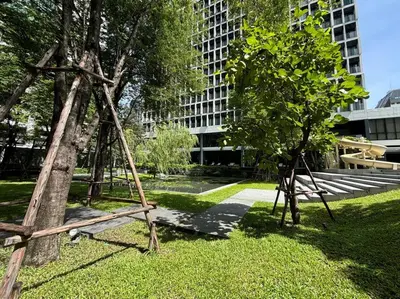 a swing set in a park with a tree at King Bed Studio in Bangkok