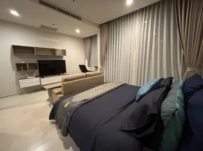 a bedroom with a bed and a couch and a television at King Bed Studio in Bangkok