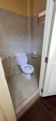 a bathroom with a white toilet in a room at Kanyakorn House Near Khao San in Bangkok