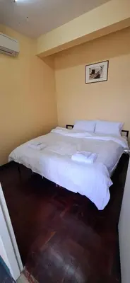 a bedroom with a large bed with white sheets at Kanyakorn House Near Khao San in Bangkok