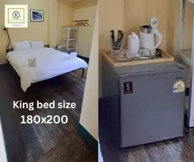 a bedroom with a king bed and a small refrigerator at Kanyakorn House Near Khao San in Bangkok