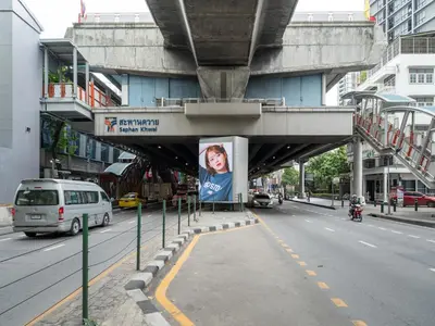 a bridge over a street with a poster of a woman at Wash House Chatuchak in Bangkok