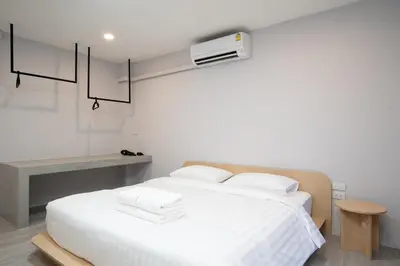 a bedroom with a white bed with a air conditioner at Wash House Chatuchak in Bangkok