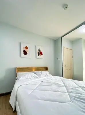 a bedroom with a large white bed with a large mirror at Tranquil Urban Retreat at Cheangwattana in Pak Kret