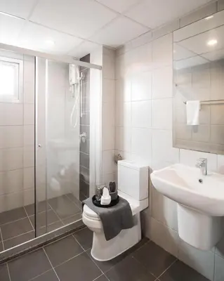 a bathroom with a toilet and a sink and a shower at Tranquil Urban Retreat at Cheangwattana in Pak Kret