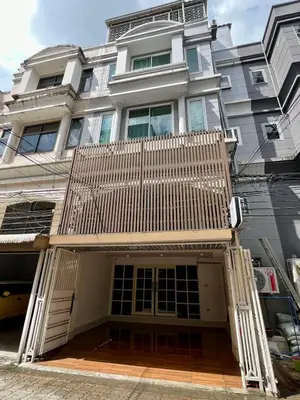 a large white house with a wooden gate on it at Comfy Crib Hostel 2 in Bangkok