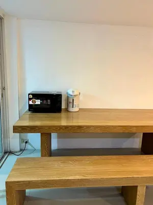a table with a toaster and a coffee cup on it at Comfy Crib Hostel 2 in Bangkok