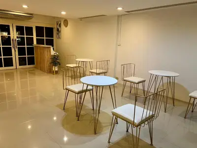 a group of tables and chairs in a room at Comfy Crib Hostel 2 in Bangkok