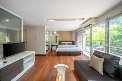 a bedroom with a bed and a tv and a couch at Story At Bangkok- 211 Studio with Balcony in Khlong Toei