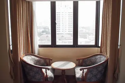 a room with two chairs and a table and a window at Spacious room in Sukhumvit Nana in Bangkok