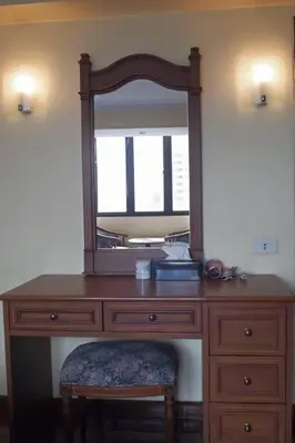 a wooden dresser with a mirror on top of it at Spacious room in Sukhumvit Nana in Bangkok