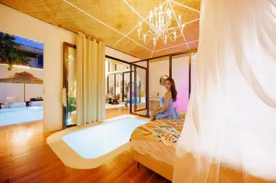 a woman sitting on a bed in a room with a bathtub at Fira\u5e7d\u5883 \u66fc\u8c37\u72ec\u4e00\u65e0\u4e8c\u6c34\u7cfb\u5367\u5ba47\u53676\u536b\u6cf3\u6c60\u522b\u5885 in Bangkok