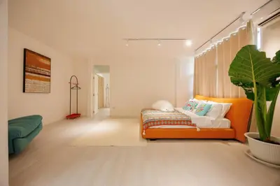 a living room with an orange couch and a plant at Fira\u5e7d\u5883 \u66fc\u8c37\u72ec\u4e00\u65e0\u4e8c\u6c34\u7cfb\u5367\u5ba47\u53676\u536b\u6cf3\u6c60\u522b\u5885 in Bangkok