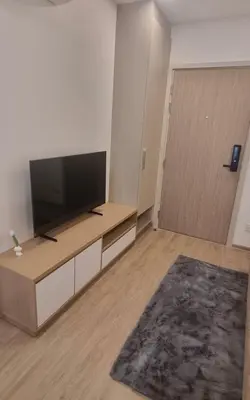 a living room with a flat screen tv and a door at Modern room with Pool and Gym in the city center just 600m from Subway station! in Bangkok