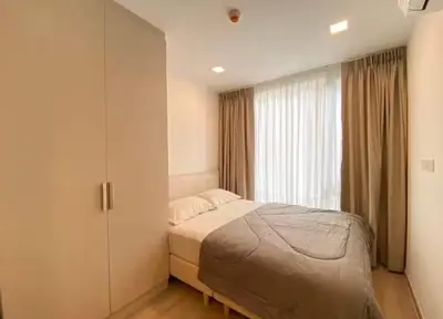 a bedroom with a bed and a large window at Modern room with Pool and Gym in the city center just 600m from Subway station! in Bangkok