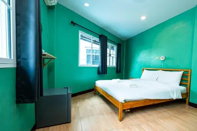 a green bedroom with a bed and a tv at xx GO INN The Giant Swing โก อินน์ เสาชิงช้า in Bangkok