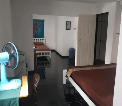 a room with a room with a fan and a table at Jay Jay Guesthouse in Bangkok