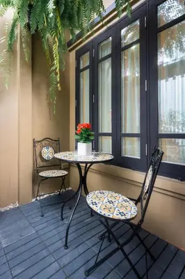 a table and two chairs sitting on a porch at Mak Sukhumvit 15 in Bangkok
