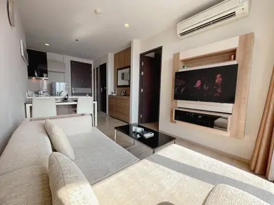 a living room with a couch and a flat screen tv at Opulence Riverview with Train Access in Bangkok