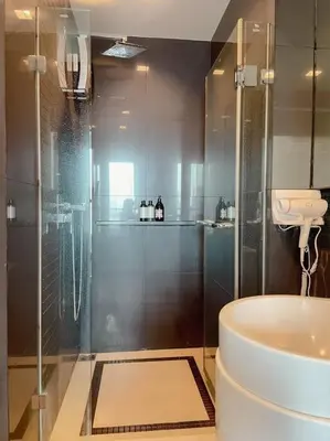 a bathroom with a glass shower and a toilet at Opulence Riverview with Train Access in Bangkok