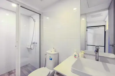 a bathroom with a toilet and a sink and a shower at Quite Grove Hotel in Bangkok