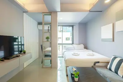 a small room with a bed and a couch at Quite Grove Hotel in Bangkok
