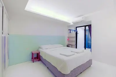 a white room with a bed and a window at Quite Grove Hotel in Bangkok