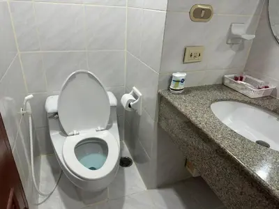a bathroom with a toilet and a sink at Spacious 1,2 & 3 Bedroom Serviced Apartments OMNI - Nana BTS in Bangkok