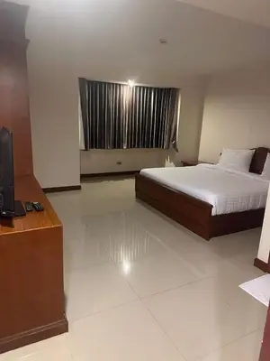 a bedroom with a bed and a television in it at Spacious 1,2 & 3 Bedroom Serviced Apartments OMNI - Nana BTS in Bangkok